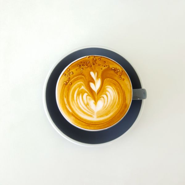 A flat white poured into a dark cup