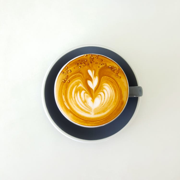 Coffee Cup With Latte Art Froth On White Surface