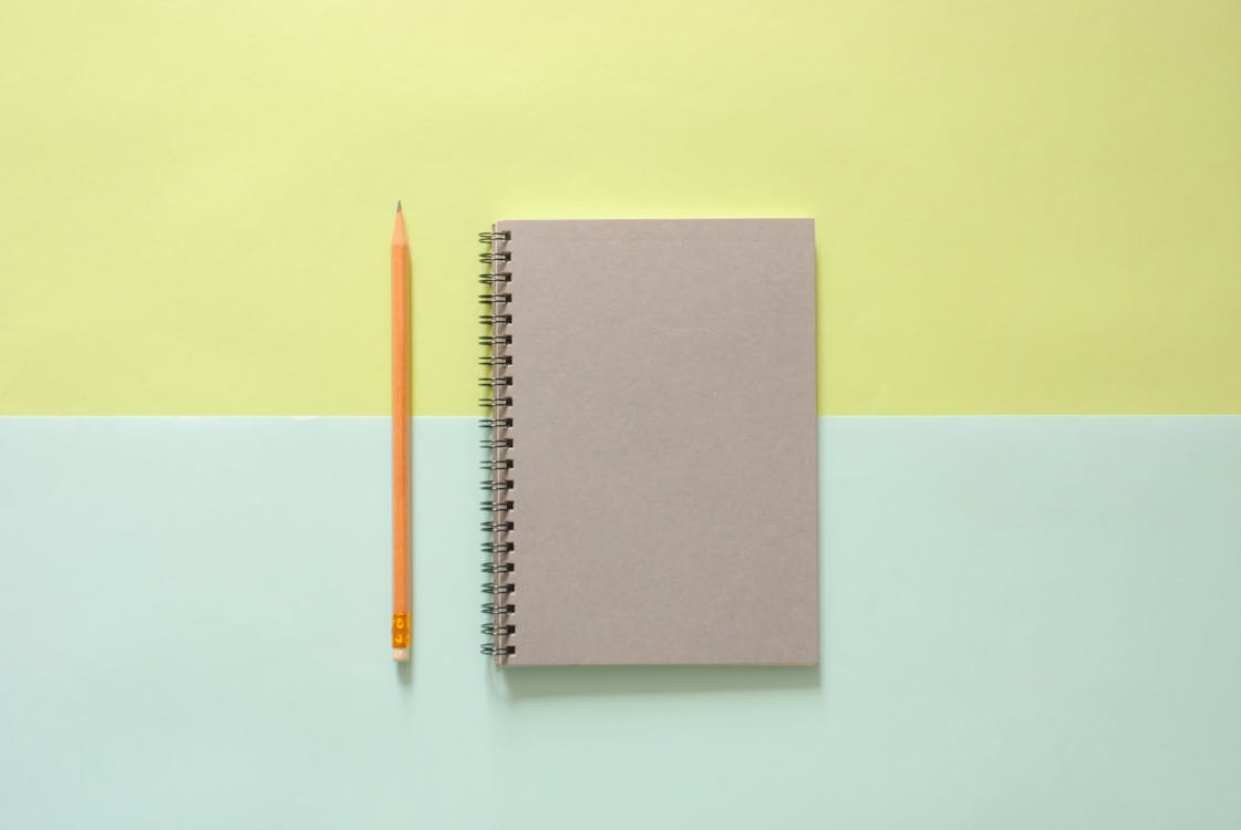 Free White Spiral Notebook Beside Orange Pencil Stock Photo
