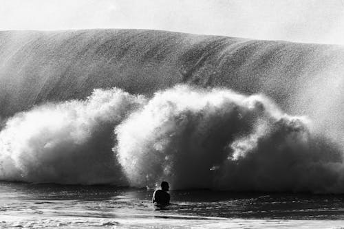 Silhouette of anonymous man near wave