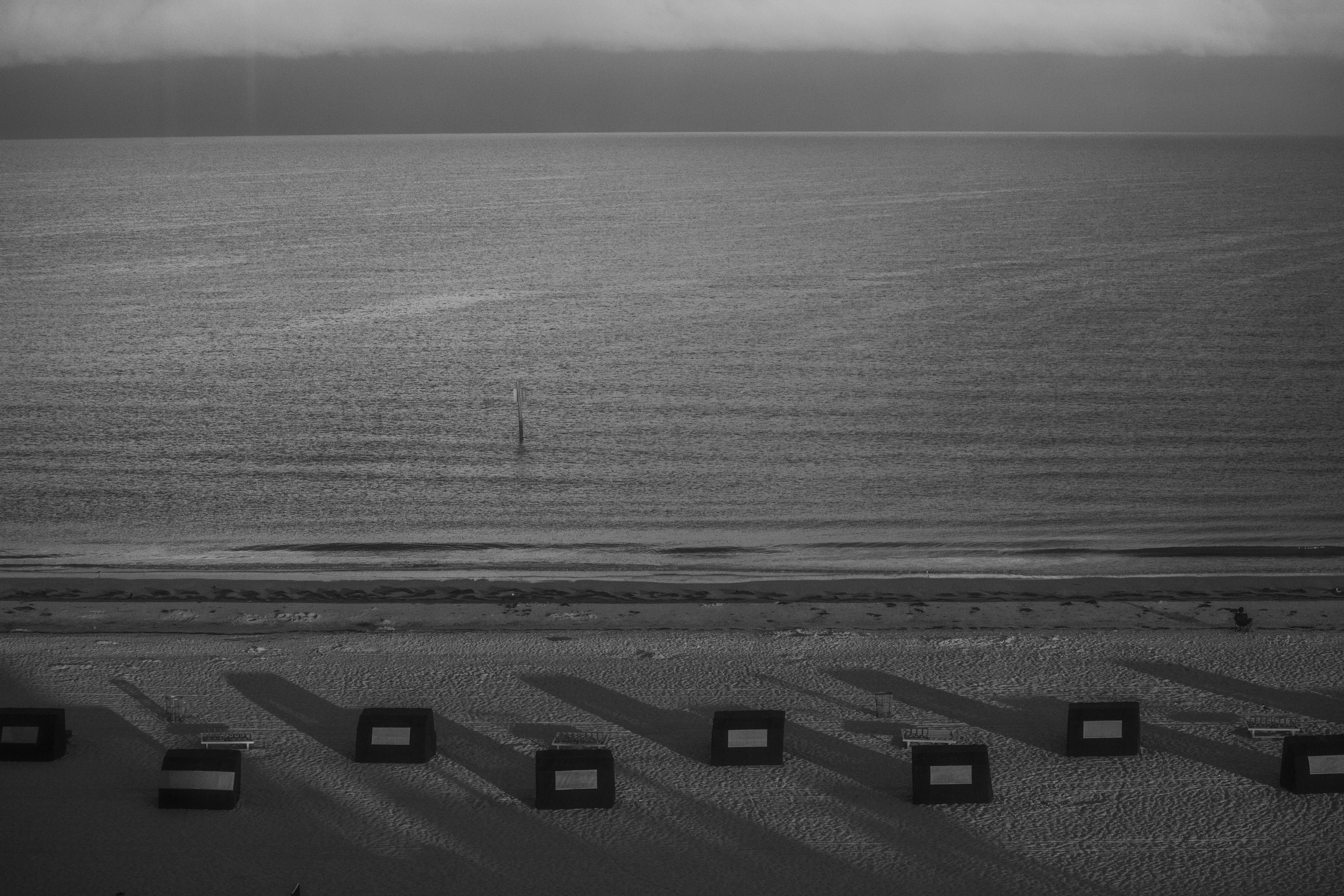 A serene black and white shot of Clearwater Beach, displaying empty cabanas and a calming ocean view.