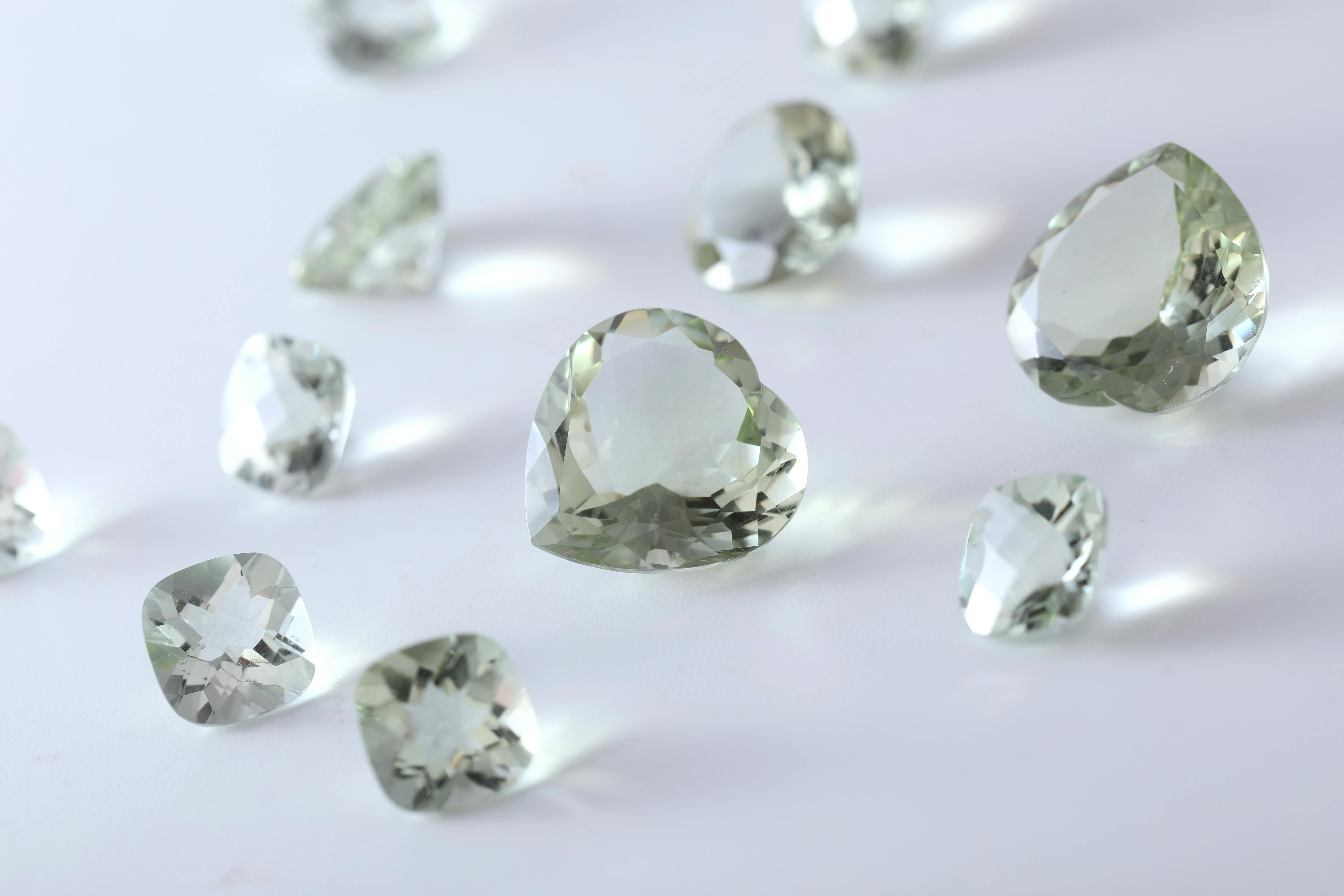 Green and Clear Gemstone on White Surface · Free Stock Photo