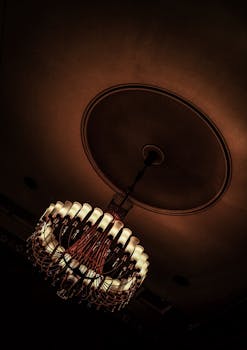 A classic chandelier casts warm light with intricate design and shadow play.