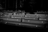 在柔和的灯光下，教堂长凳的黑白图像宁静安详，营造出一种平和而引人沉思的氛围