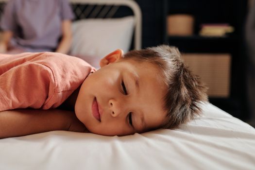 年幼的孩子在舒适的卧室里安然入睡，显得宁静而安详