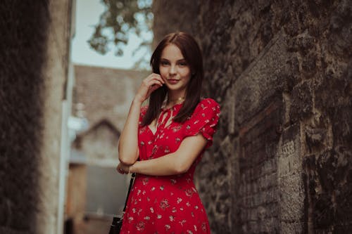 Selective Focus Photo of a Beautiful Woman in a Red Dress Looking at the Camera