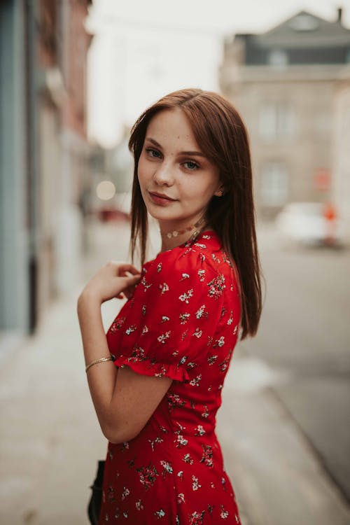 Free Woman in a Red and White Floral Dress Looking at the Camera Stock Photo