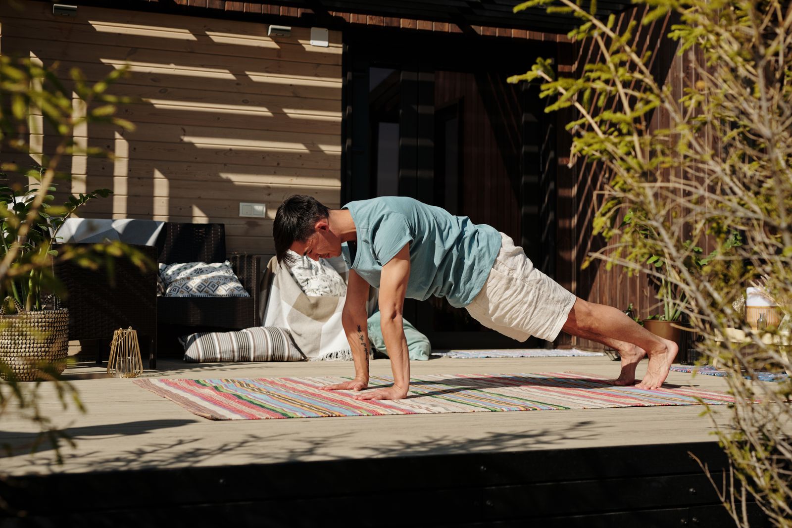 Man holding a plank pose on a yoga mat to build core and shoulder strength