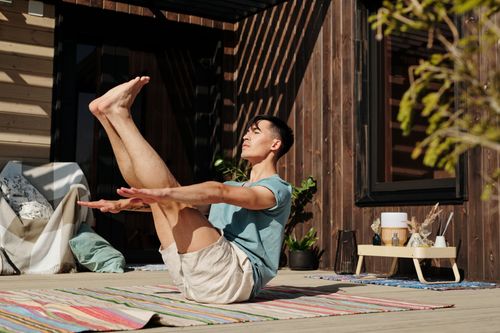 Free Man practicing yoga outdoors on a sunny day, showcasing balance and flexibility. Stock Photo