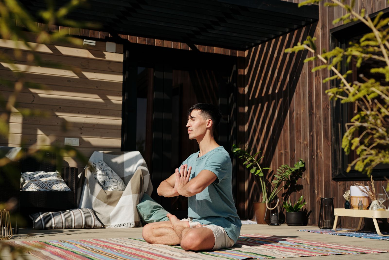Person sitting cross-legged with eyes closed practicing breath-focused meditation indoors