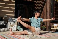 Man in Teal Crew Neck T-shirt in Leg Stretch Pose