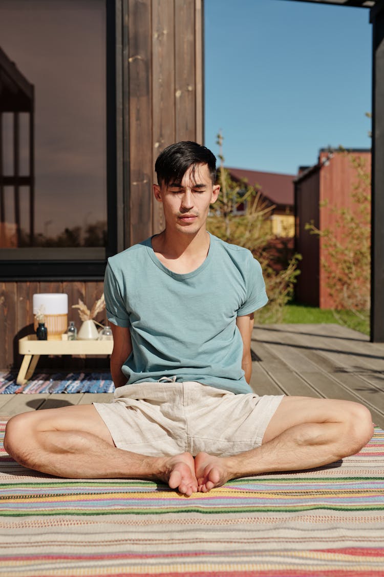 Man Sitting In Yoga Pose With Bended Knees