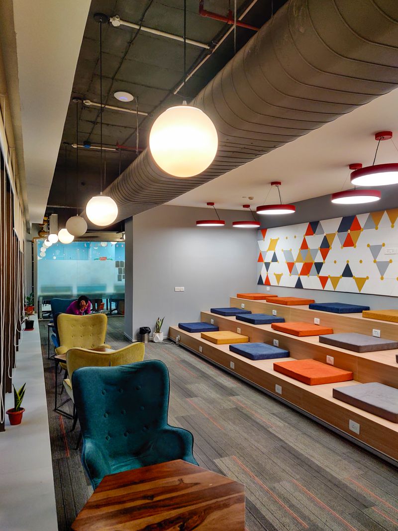 A stylish and vibrant office interior with colorful seating in Gurugram, India