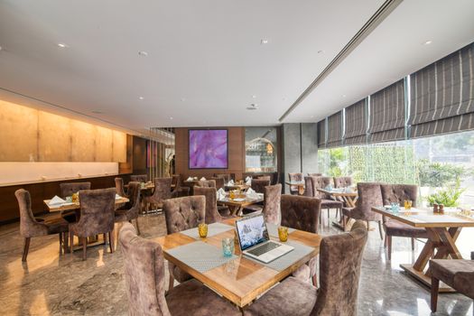 Spacious and elegant restaurant interior with modern furnishings and natural lighting.
