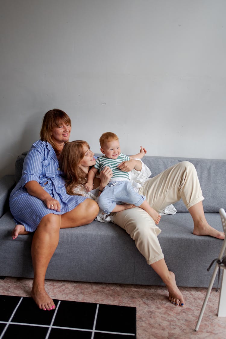 Positive Granny And Daughter With Baby Having Fun On Couch