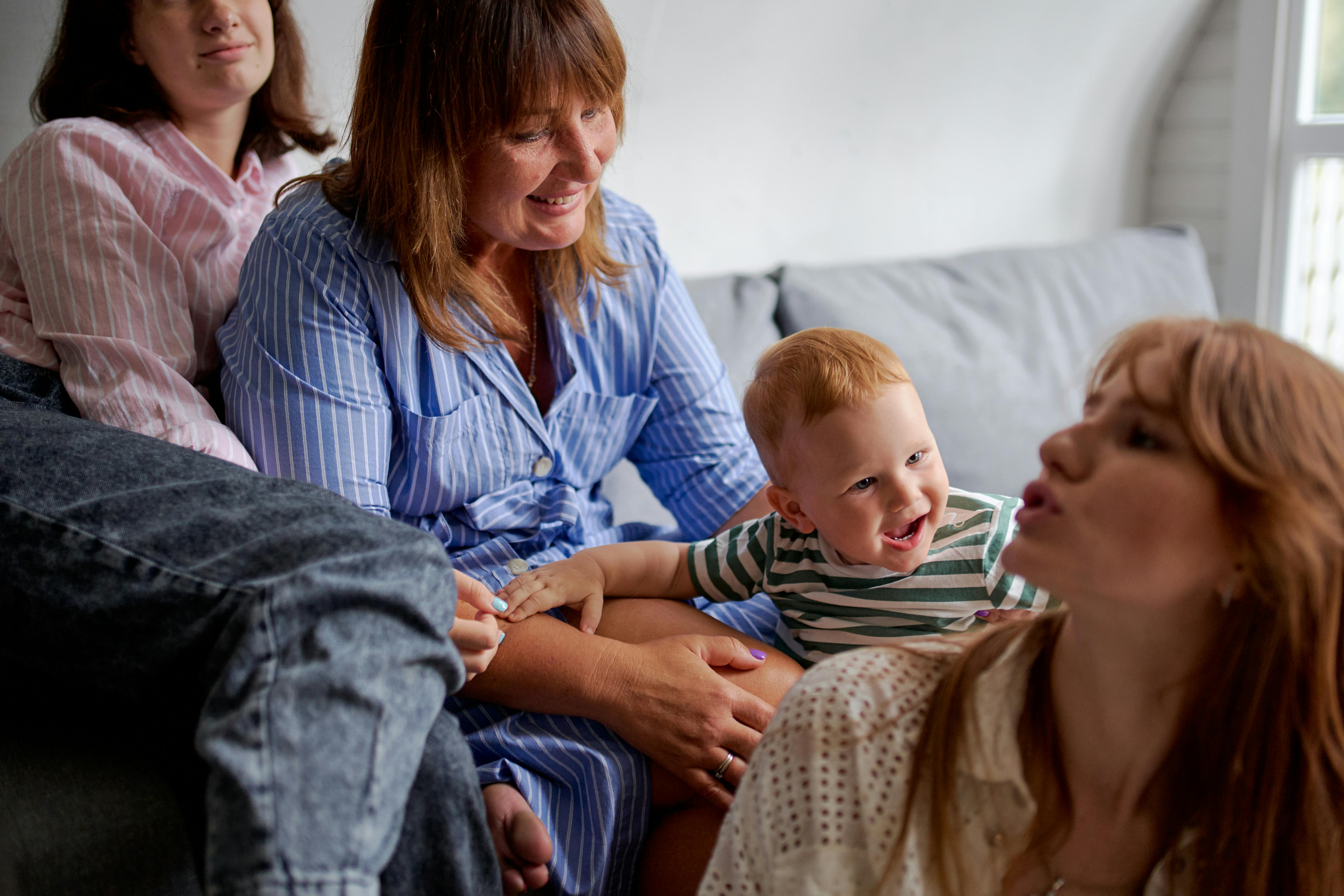 crop women spending time with smiling toddler boy at home