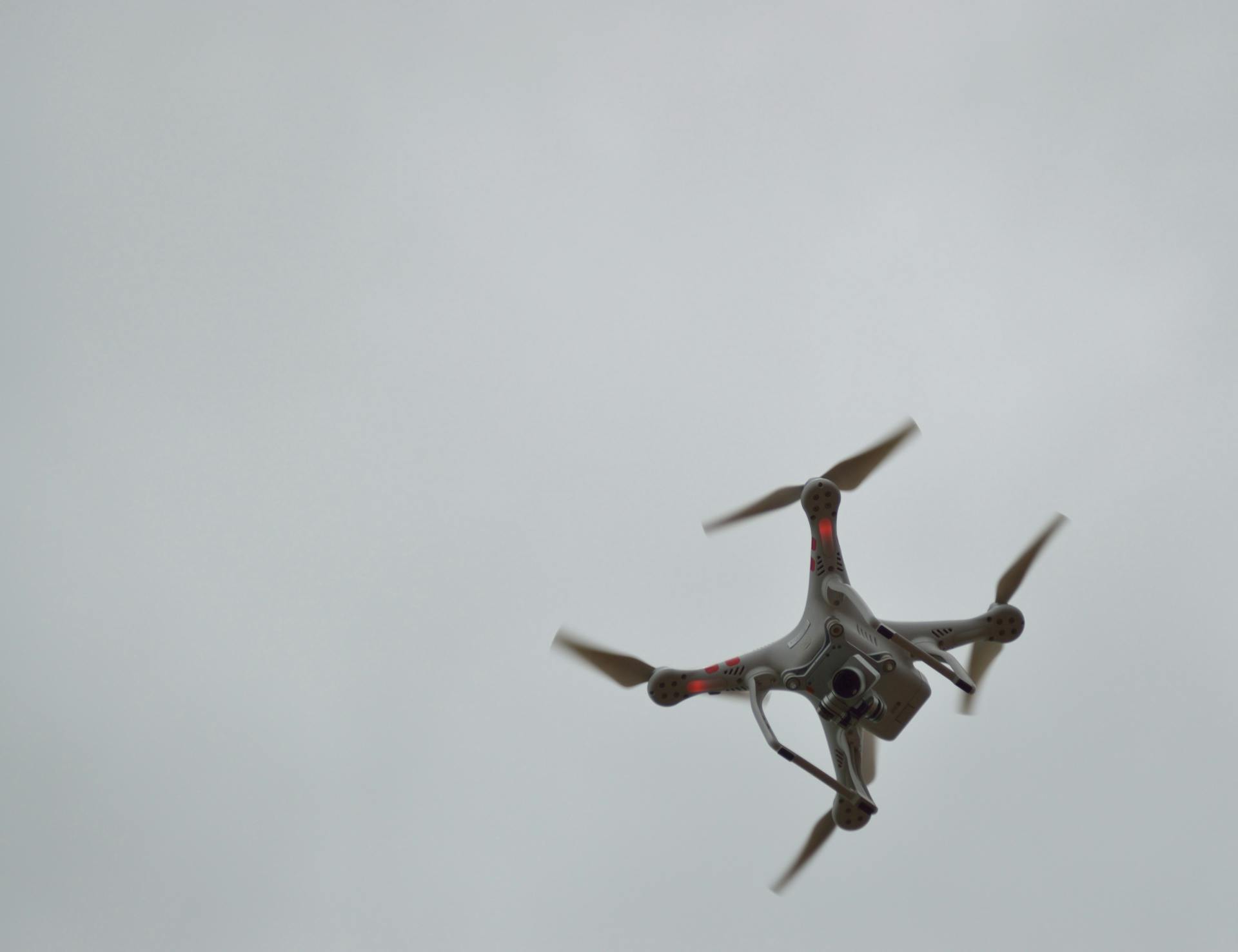 A quadcopter drone in flight against a cloudy sky, showcasing modern technology.