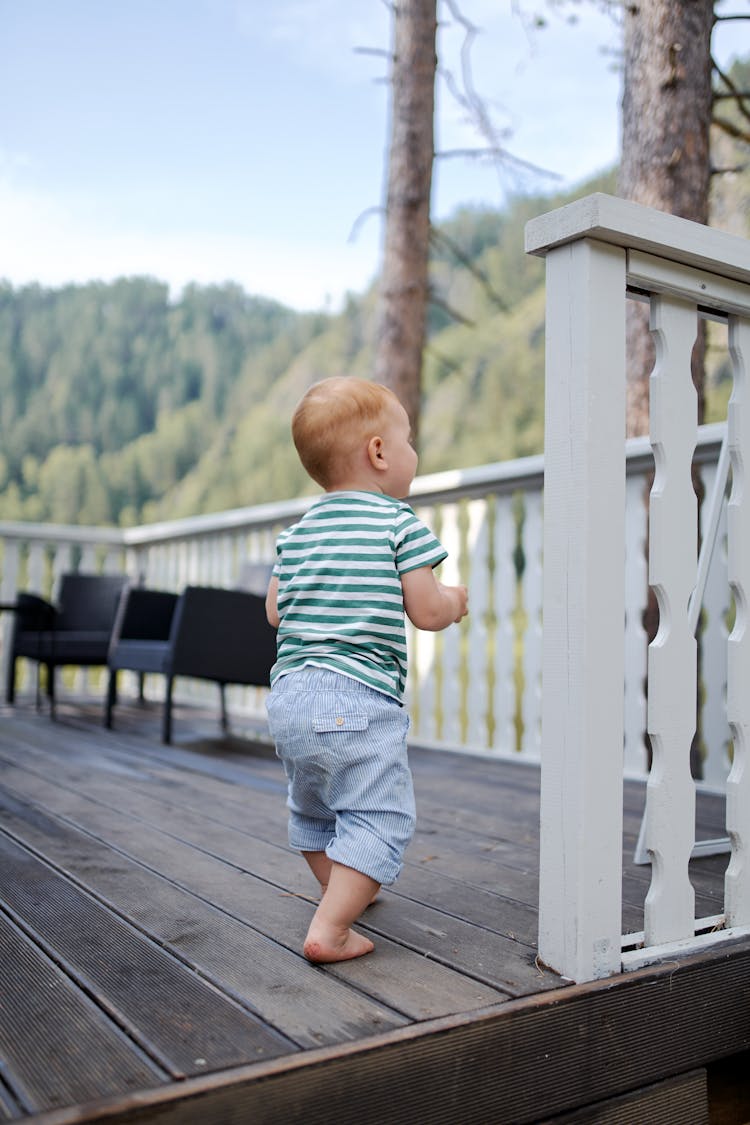 Unrecognizable Toddler Child Walking On Terrace In Summer