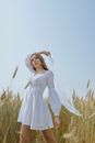 Feminine woman with scarf in hand standing on summer field