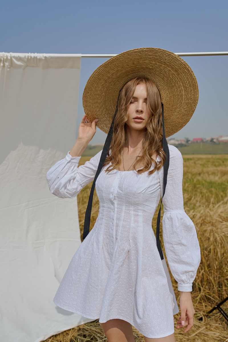 Woman in a white summer dress standing in a field