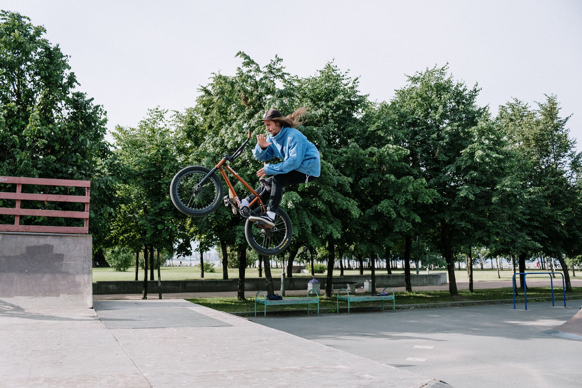 A skilled BMX rider performs a mid-air trick in an outdoor skatepark, showcasing extreme sports prowess.