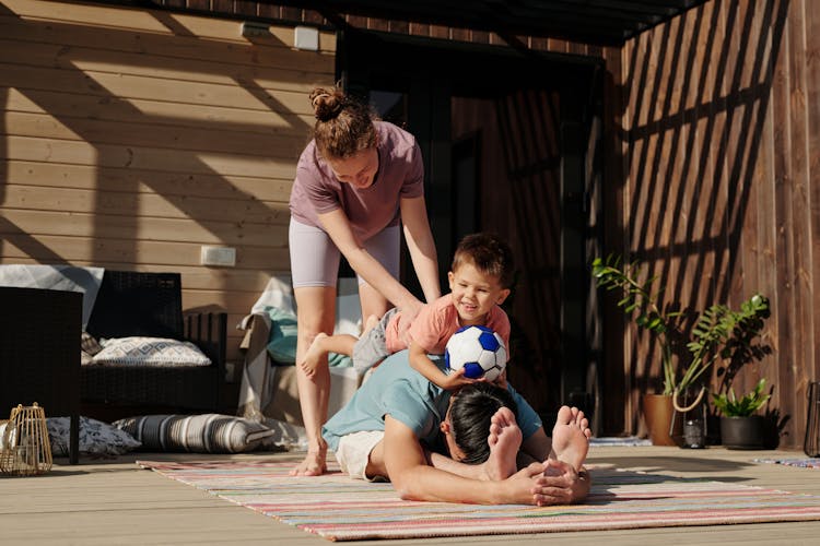 A Happy Family At The Porch Working Out Together