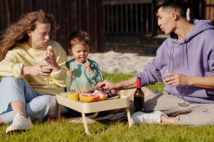 A Family Having Picnic On The Backyard