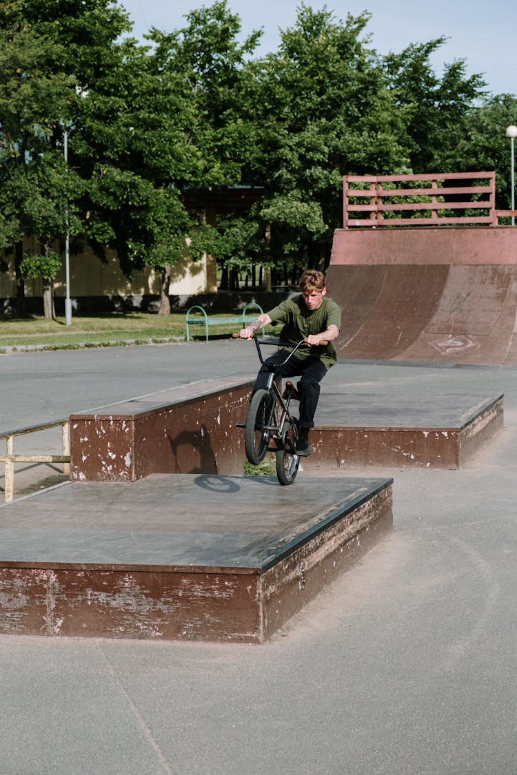 A Man Riding A Bike On A Skatepark