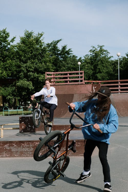 Free Two Persons Doing Bicycle Tricks on a Skatepark Stock Photo