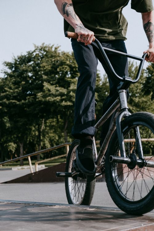 Free A BMX cyclist performs a trick at a skatepark, showcasing skill and energy on a sunny day. Stock Photo