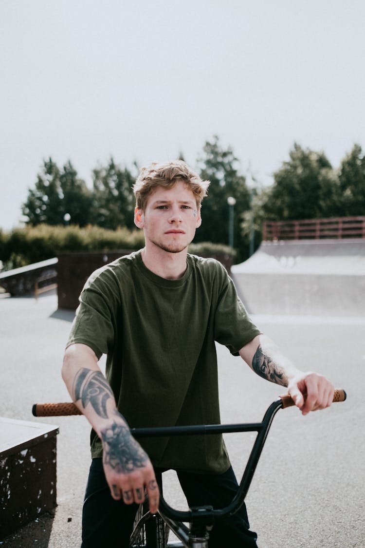 A Tattooed Man Riding A Bicycle