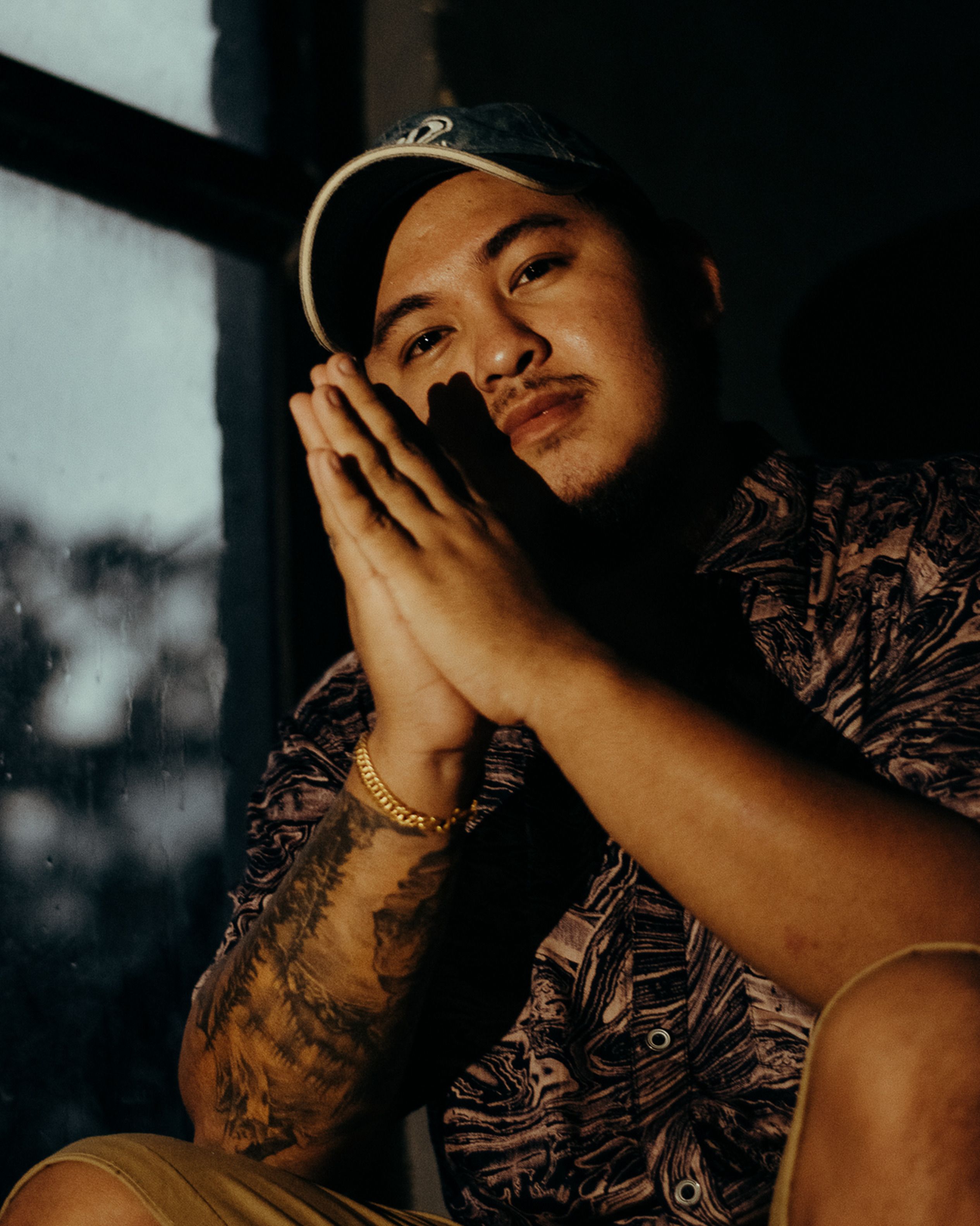Warm-toned portrait of a man in Nepal, showcasing thoughtful expression and cultural tattoos.
