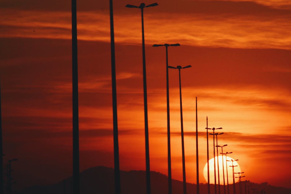 Streetlights silhouetted against a dramatic sunset in Rio de Janeiro, Brazil.
