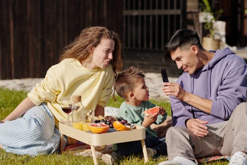 Free A Family Sitting on the Grass Stock Photo