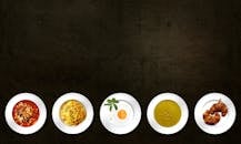Five White Plates With Different Kinds of Dishes