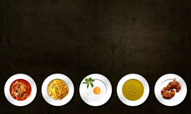 Flatlay of various dishes including pasta, egg, soup, and croissant on textured background.
