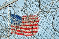 透过铁丝网看到的美国国旗，象征着自由与保护