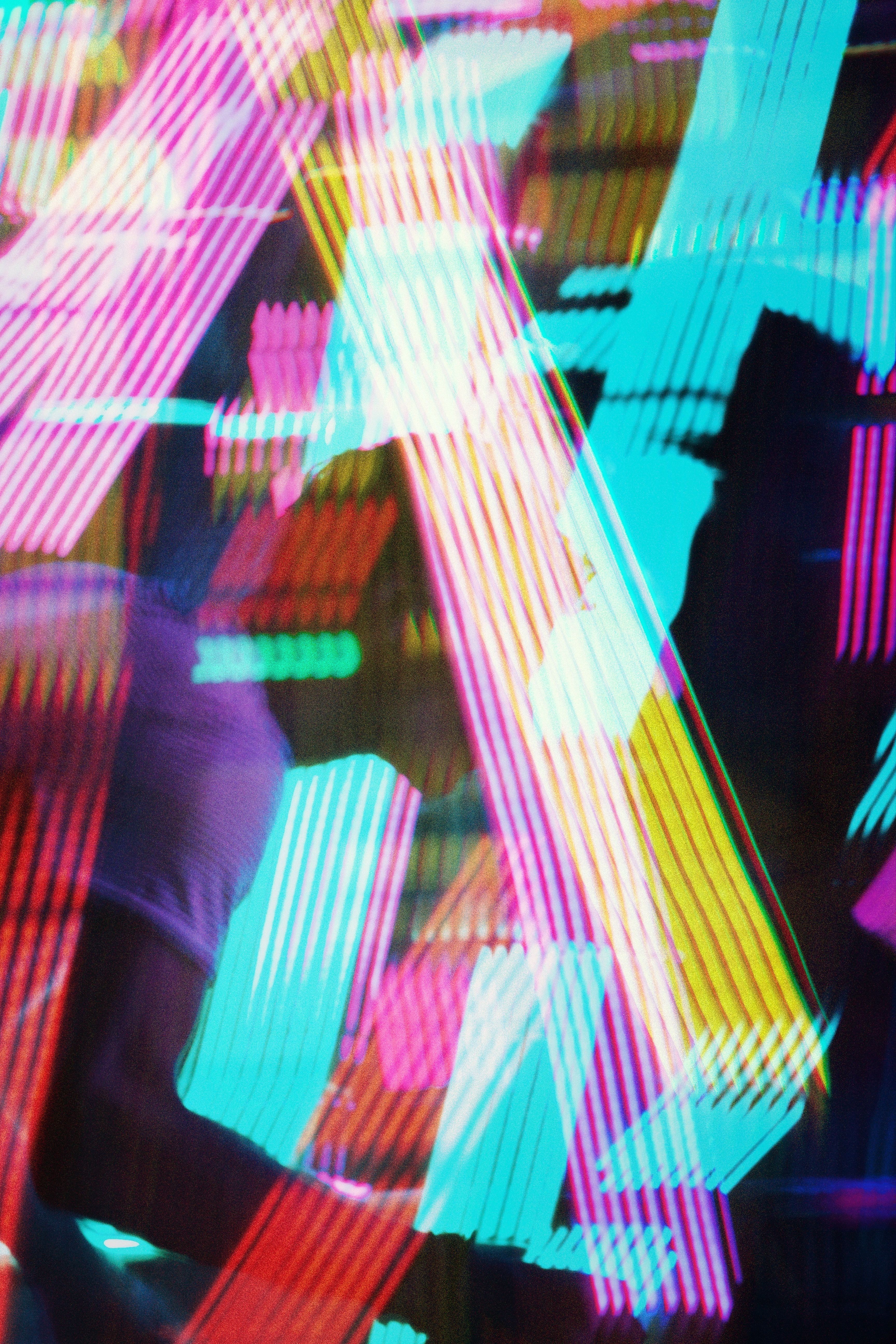 Colorful abstract patterns created by vibrant neon lights reflecting dynamic motion.