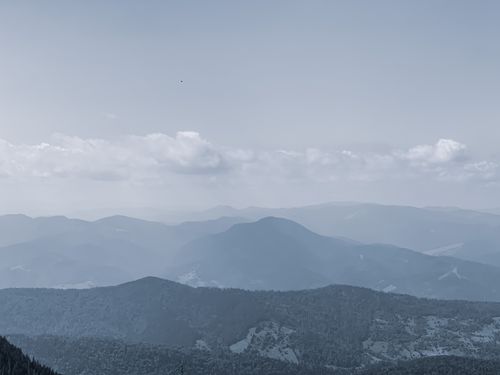 Free From above of picturesque mountain with trees in mist under gray cloudy sky Stock Photo