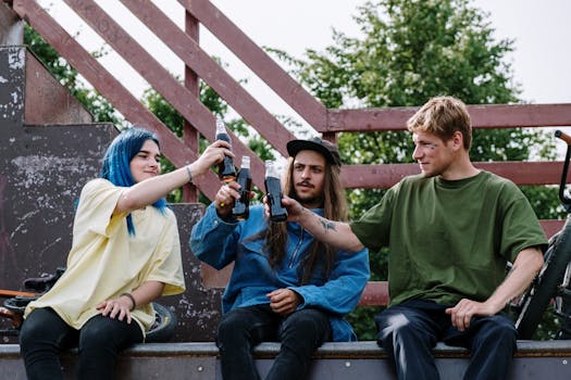 Group of friends toasting with soda bottles at an outdoor skatepark, enjoying togetherness.