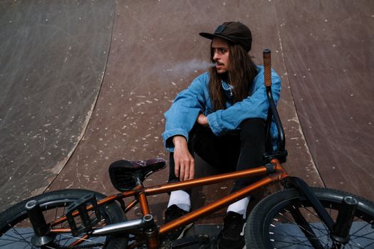 Woman in Blue Denim Jacket and Black Pants Sitting on Black Wheel Chair