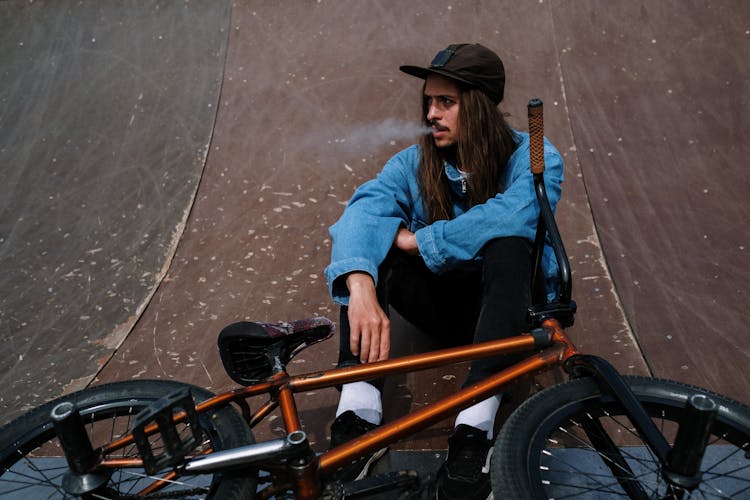 Man Smoking Cigarette While Sitting On A Ramp 