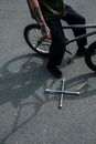 Person in Pants and Black Shoes on a Bicycle Near a Tools