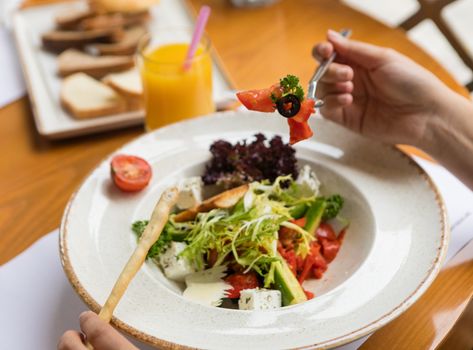 A fresh Greek salad with feta cheese and vegetables on a sunny day.