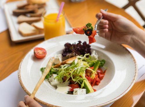 Free A fresh Greek salad with feta cheese and vegetables on a sunny day. Stock Photo