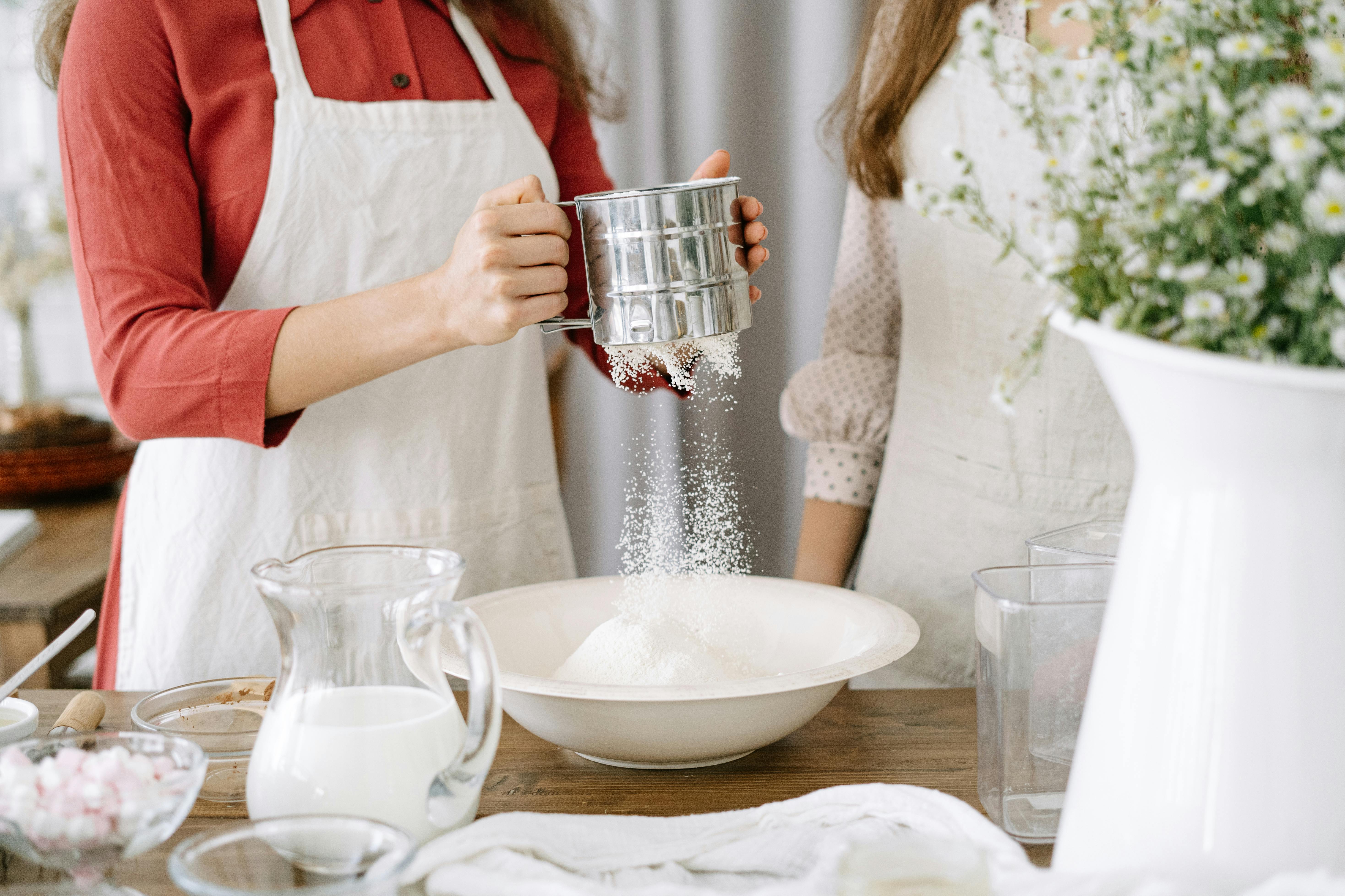 woman wearing an apron holding a sifter