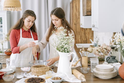 Free Two Women Mixing Ingredients in a Glass Bowl Stock Photo
