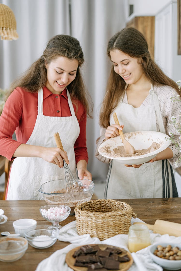 Two Women Holding Bowls Mixing Ingredients