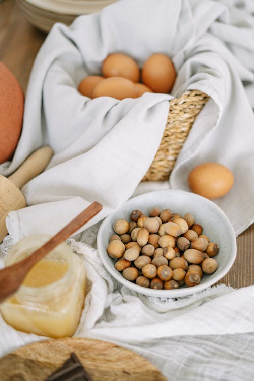 Free Brown Eggs on White Cloth in a Woven Basket Stock Photo