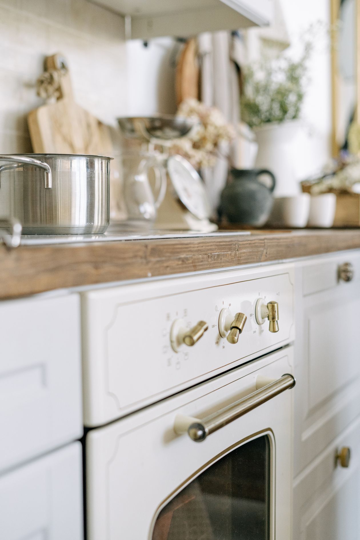 Vintage white stove with brass knobs in a rustic kitchen